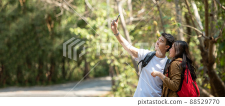 Tourist and traveler asian couple backpack enjoy happy take a photo selfie in the jungle forest nature park . 88529770