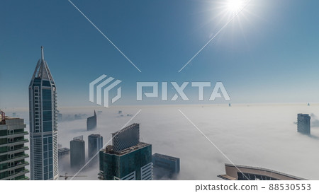 Rare early morning winter fog above the Dubai Marina skyline and skyscrapers rooftops aerial timelapse. 88530553