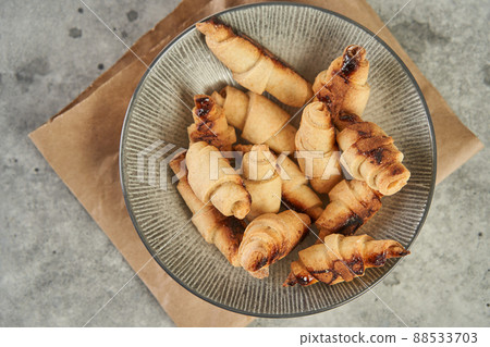 Russian slavic traditional pastry called roguelikes. Cakes bagels. Crispy croissants. Food on grey background, Copy space Russian slavic traditional pastry called roguelikes. Cakes bagels. Crispy croissants. Food on grey background, Copy space 88533703