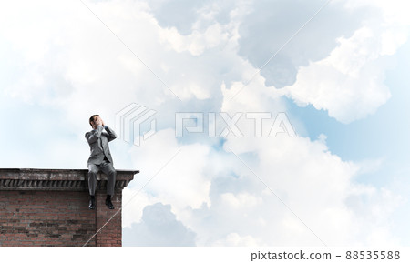 Young man on building edge do not want to see anything Young man on building edge do not want to see anything 88535588