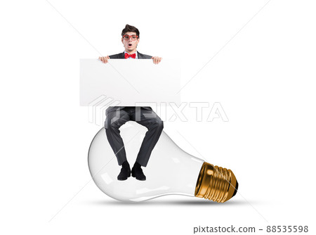 A young businessman sits on a light bulb A young businessman sits on a light bulb 88535598
