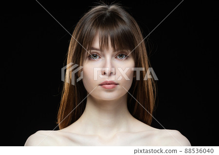 Close-up portrait of a young woman on a black background. Close-up portrait of a young woman on a black background. 88536040