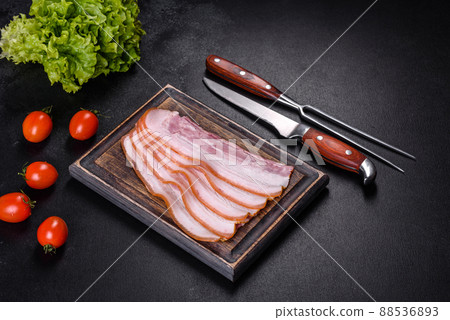 Slices of bacon on a wooden cutting Board. Pork meat Slices of bacon on a wooden cutting Board. Pork meat 88536893