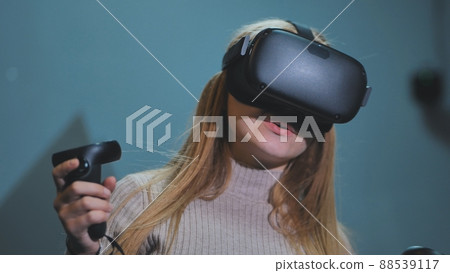The girl plays virtual reality games in the club. The girl plays virtual reality games in the club. 88539117