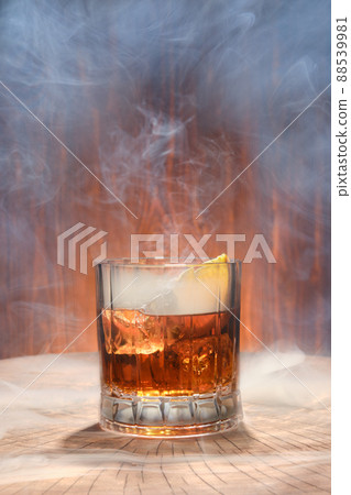 Cocktail with smoked whisky on the lid of barrel 88539981