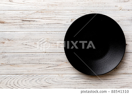 Top view of black plate on wooden background. Empty space for your design Top view of black plate on wooden background. Empty space for your design 88541310