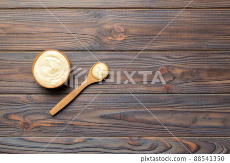 Cheese sauce in wooden bowl with spoon on wood background. Top view with copy space Cheese sauce in wooden bowl with spoon on wood background. Top view with copy space 88541350