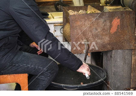 A man turns homemade device for extracting cedar A man turns homemade device for extracting cedar 88541569