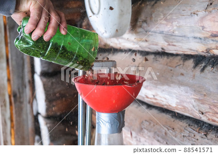 A man blows nuts from small debris using DIY 88541571