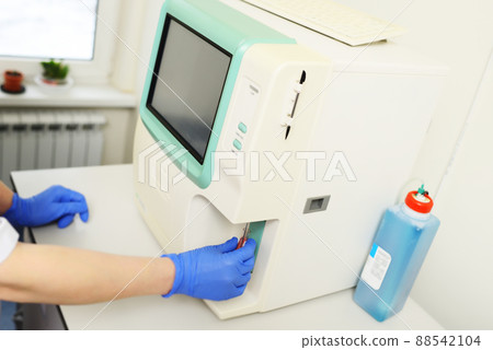 laboratory assistant examines a blood sample in an analyzer in a modern microbiological clinic. laboratory assistant examines a blood sample in an analyzer in a modern microbiological clinic. 88542104
