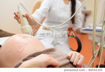 doctor does an ultrasound examination of the fetus of a pregnant woman in a modern clinic. doctor does an ultrasound examination of the fetus of a pregnant woman in a modern clinic. 88542105