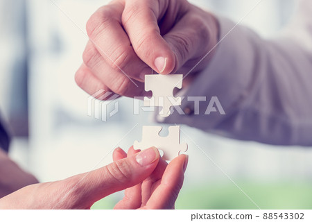 Retro vintage style image of a businesspeople fitting together puzzle pieces Retro vintage style image of a businesspeople fitting together puzzle pieces 88543302