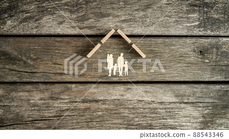 Family home concept with a cut out of a young family with children Family home concept with a cut out of a young family with children 88543346