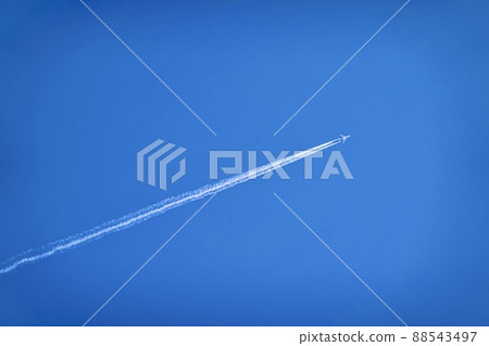 一架在藍天上留下白雲的客機 88543497