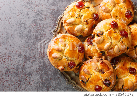 Delicious English scones Fat Rascals with dried fruits and almonds close-up in a plate. horizontal top view 88545172