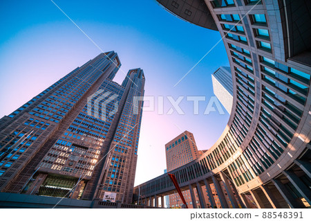 Tokyo cityscape of Japan View of the Tokyo Metropolitan Government Building bathing in the setting sun and aircraft passing over the sky 88548391