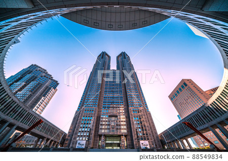 Tokyo cityscape of Japan View of the Tokyo Metropolitan Government Building bathing in the setting sun and aircraft passing over the sky 88549834