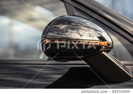 Close-up of the side right mirror and window of the black car body. Auto service industry. Road safety while driving. 88550094