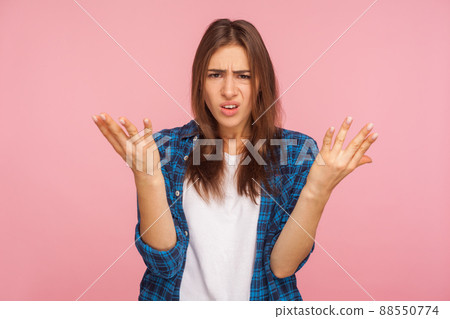 What do you want. Portrait of annoyed girl in checkered shirt raising arms in questioning gesture, saying I don't understand problem, looking indignant. indoor studio shot isolated on pink background 88550774