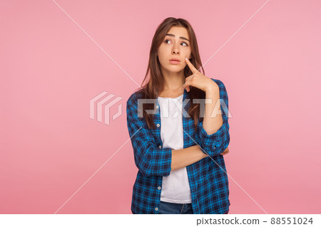 Need to think over difficult decision. Portrait of pensive girl in checkered shirt looking aside with doubtful thoughtful face, pondering intensely concentrating. indoor studio shot, pink background Need to think over difficult decision. Portrait of pensive girl in checkered shirt looking aside with doubtful thoughtful face, pondering intensely concentrating. indoor studio shot, pink background 88551024