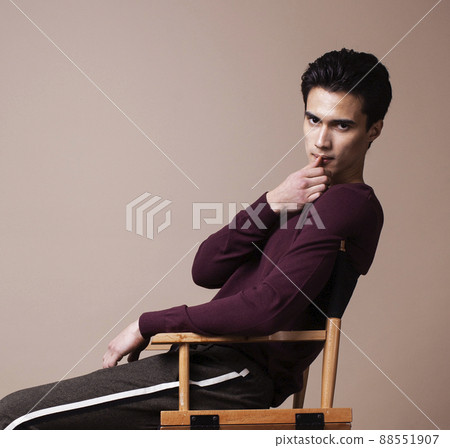 young pretty asian man posing in fashion style on light brown background, lifestyle people concept young pretty asian man posing in fashion style on light brown background, lifestyle people concept 88551907