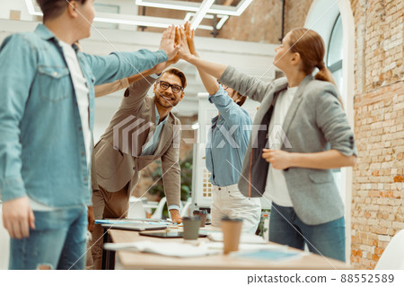 Smiling colleagues showing team work in office Smiling colleagues showing team work in office 88552589
