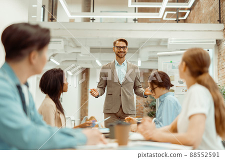 Colleague making a presentation while standing in the office Colleague making a presentation while standing in the office 88552591