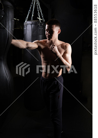 Blows practices bag boxer athlete The the glove black young male body, for strong gloves from fight from caucasian guy, sportswear martial. Backlit victory people, 88553618
