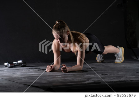 The stands plank girl on in a with the dumbbells floor push-ups looks like a kira knightley girl plank workout, from body fit in exercise from active isolated, sportswear biceps. Wellness sweat 88553679
