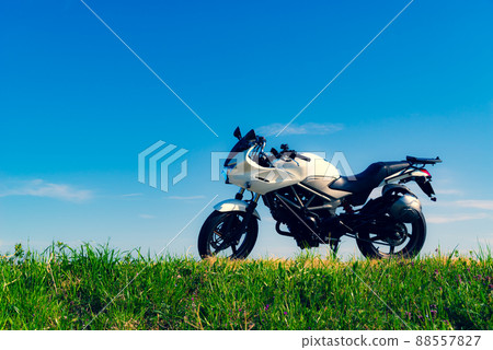 Bike touring in fine weather On a hill with grass against the background of blue sky b-3 Space Large Warm and cool colors emphasized Bike touring in fine weather On a hill with grass against the background of blue sky b-3 Space Large Warm and cool colors emphasized 88557827