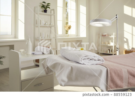 Beautician's office, spa salon, or massage room with bed, magnifying lamp and skin care products Beautician's office, spa salon, or massage room with bed, magnifying lamp and skin care products 88559123