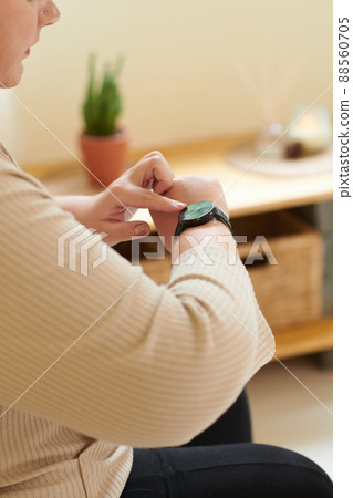 Woman Checking Fitness Tracker Woman Checking Fitness Tracker 88560705