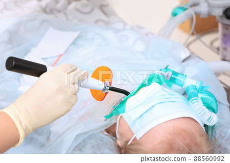The installation of the fillet on the baby teeth. Surgery under general anesthesia. A breathing tube in the baby's mouth. A photo in a real operating room. The installation of the fillet on the baby teeth. Surgery under general anesthesia. A breathing tube in the baby's mouth. A photo in a real operating room. 88560992