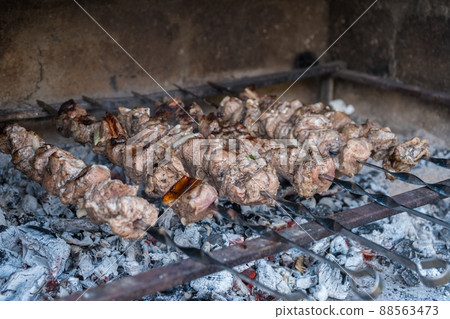Georgian mtsvadi (Shashlik) preparation. Smoking shashlik on the grill. BBQ on Stick Georgian mtsvadi (Shashlik) preparation. Smoking shashlik on the grill. BBQ on Stick 88563473