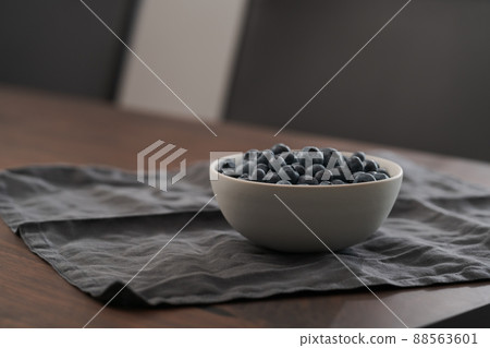 Fresh blueberries in white bowl on wood table 88563601