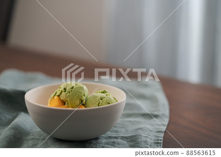 green matcha tea ice cream with fresh mango in white bowl 88563615
