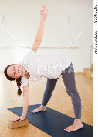 Pregnant woman is engaged in yoga. Elongated Triangle Pose or Utthita Trikonasana 88566166