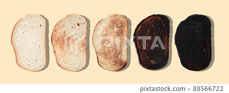 slices of bread at different stages of toasting with last one completely burnt on brown background 88566722
