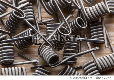 A close-up texture of a spiral for an electronic vaporizer and a cigarette. Vape, vaping A close-up texture of a spiral for an electronic vaporizer and a cigarette. Vape, vaping 88567766