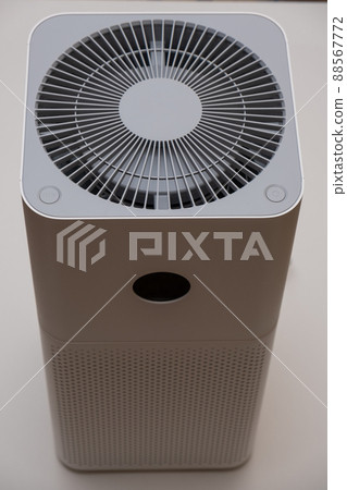 Indoor air purifier of white color close-up on a white background. Dust and allergy cleaner in the house. 88567772