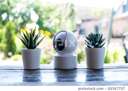 Video surveillance equipment on the table. Compact security camera for outdoor or private home security Video surveillance equipment on the table. Compact security camera for outdoor or private home security 88567787