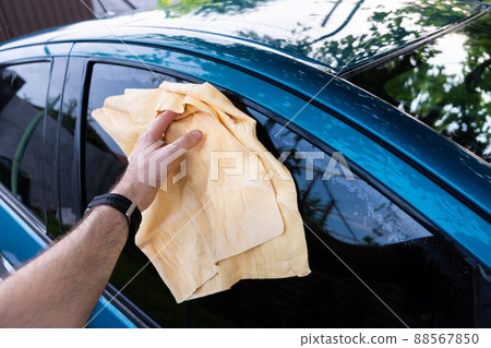 Car wash outside in the daytime. Wipe off the remnants of drops with a microfiber Car wash outside in the daytime. Wipe off the remnants of drops with a microfiber 88567850