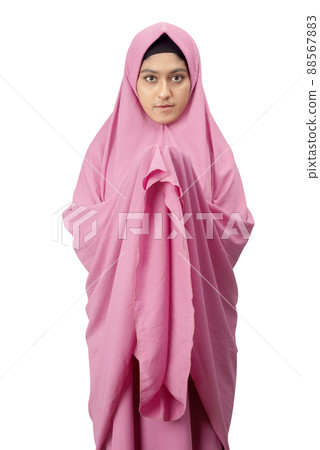 Asian Muslim woman in a veil standing while raised hands and praying 88567883