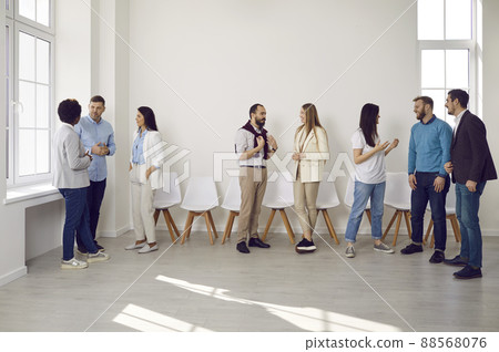 Different groups of colleagues communicate with each other during work break in coworking office. 88568076