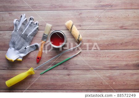 A paint brush , gloves and paint on table A paint brush , gloves and paint on table 88572249