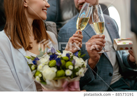 Couple in love toasting with champagne glasses in airplane Couple in love toasting with champagne glasses in airplane 88573191