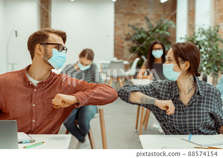 Two students bumping their elbows instead of greeting with a hug Two students bumping their elbows instead of greeting with a hug 88574154