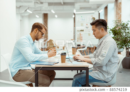 Two guys are working on a new project together Two guys are working on a new project together 88574219