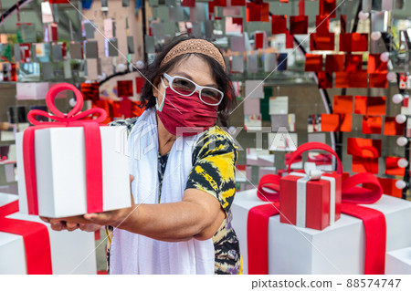 Attractive Senior Woman with Gift in Hand. 88574747