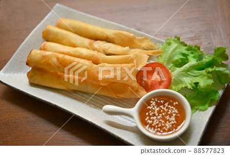 Chinese spring rolls fried with chili sauce and white sesame in a ceramic plate Chinese spring rolls fried with chili sauce and white sesame in a ceramic plate 88577823